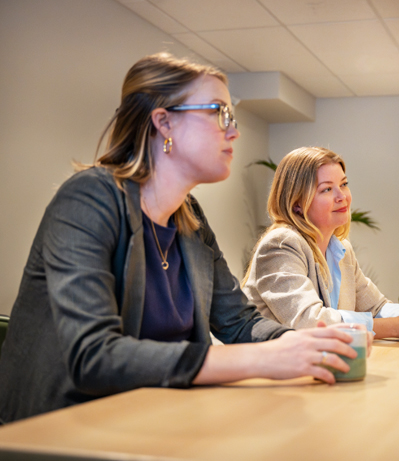 Synergy Enterprises team members in a boardroom meeting.