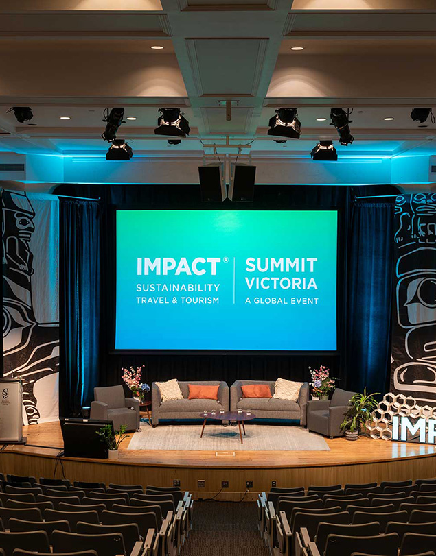IMPACT Sustainability Travel & Tourism Summit conference stage with screen, seating and Indigenous-designed banners.